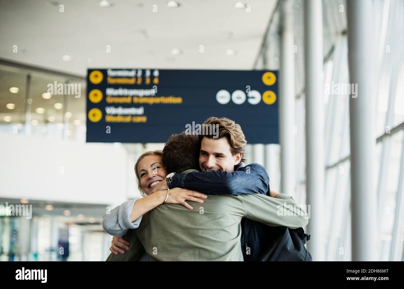 Affettuosi colleghi d'affari che abbracciano all'aeroporto Foto Stock