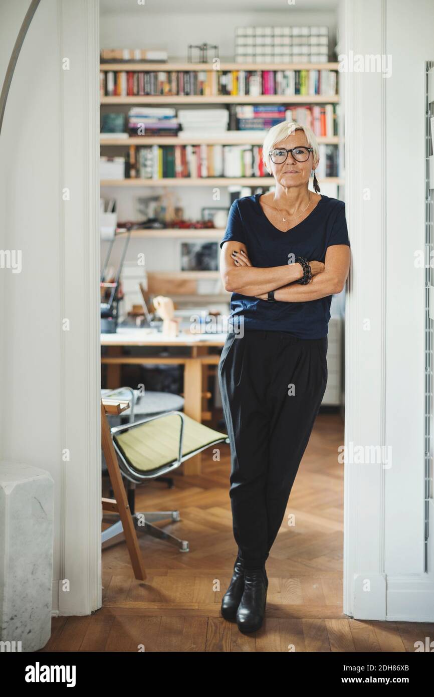 Ritratto a lunghezza intera di braccia sicure di designer incrociate a. casa Foto Stock