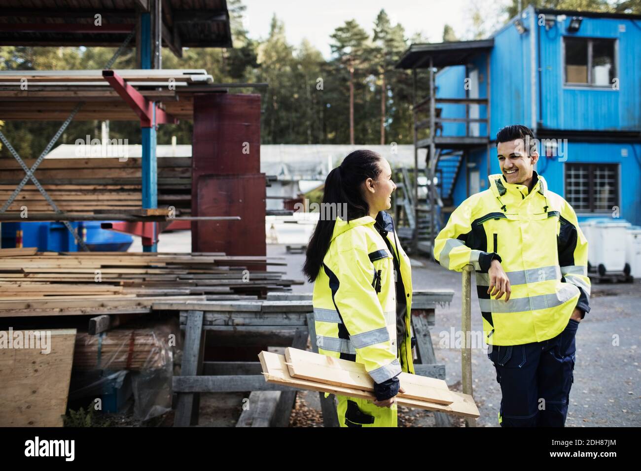 Felici studenti di carpenteria in abiti riflettenti che parlano fuori della scuola Foto Stock