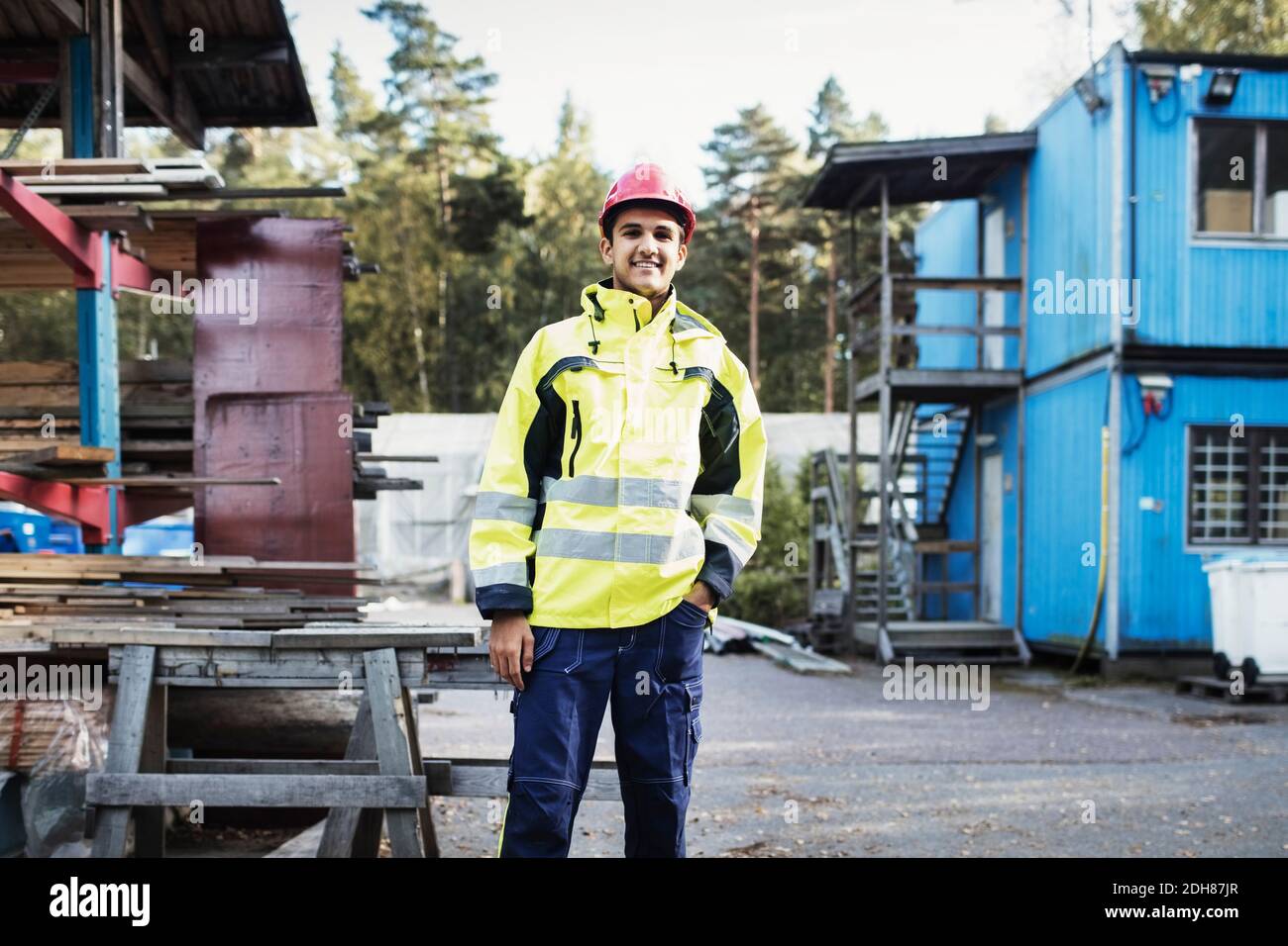 Ritratto di felice studente di carpenteria in piedi fuori dell'edificio scolastico Foto Stock