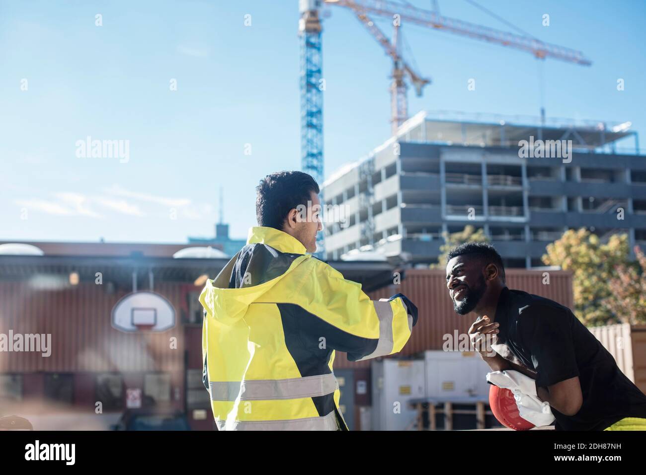 Studenti multietnici che si trovano fuori dalla scuola di meccanica auto Foto Stock