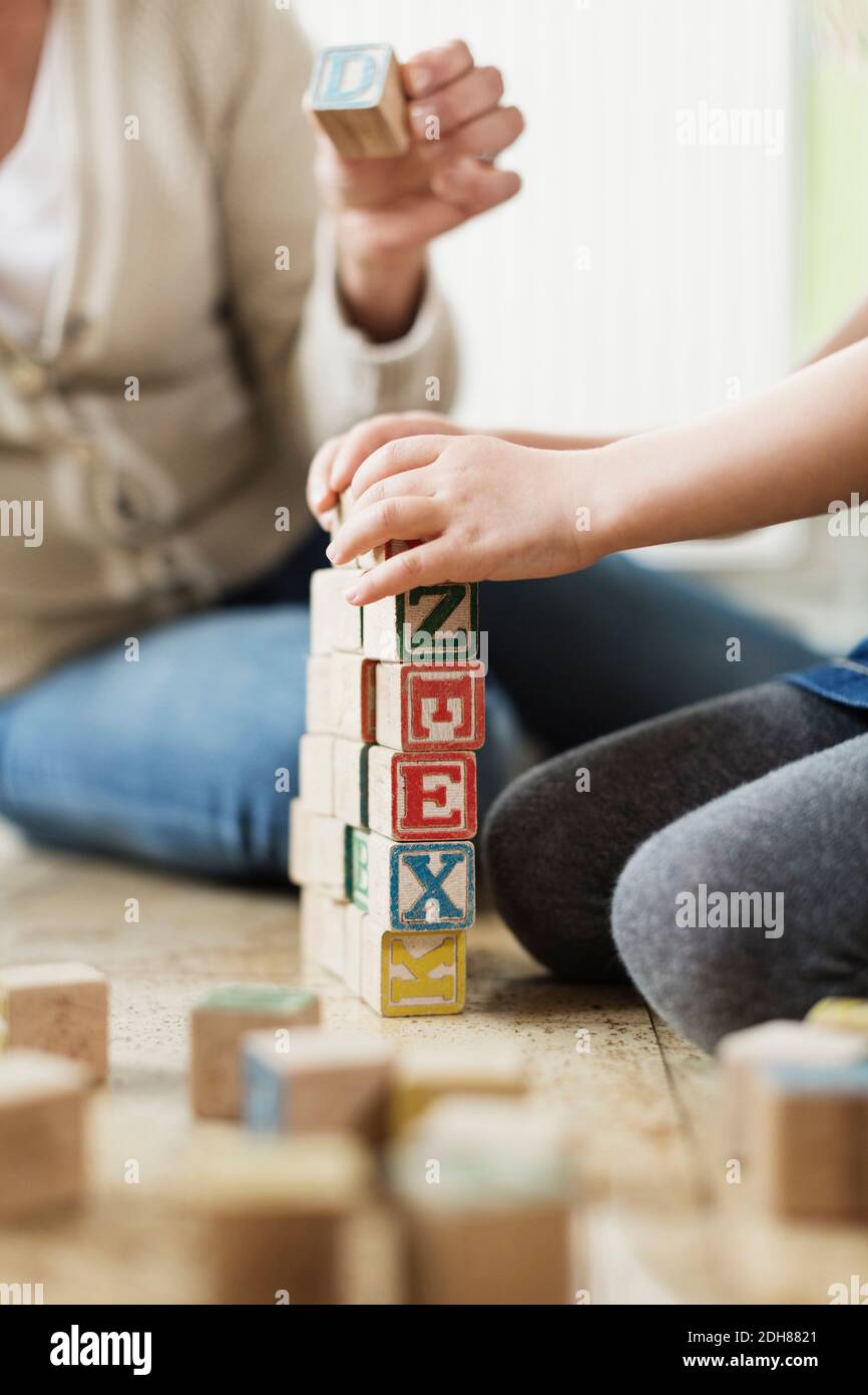 Immagine ritagliata dei blocchi di impilamento di insegnanti e studenti Foto Stock
