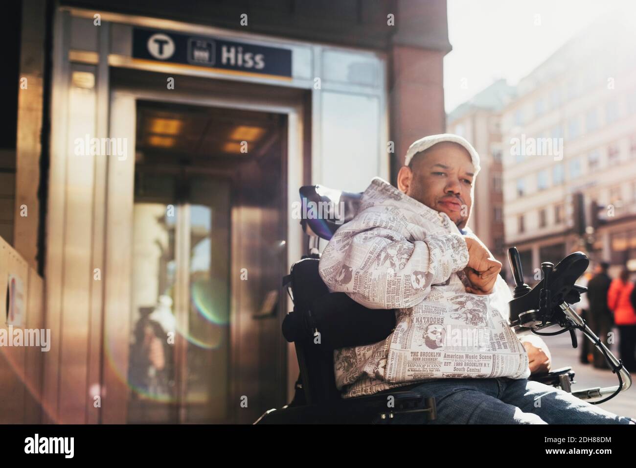Uomo disabile su sedia a rotelle motorizzata in città Foto Stock