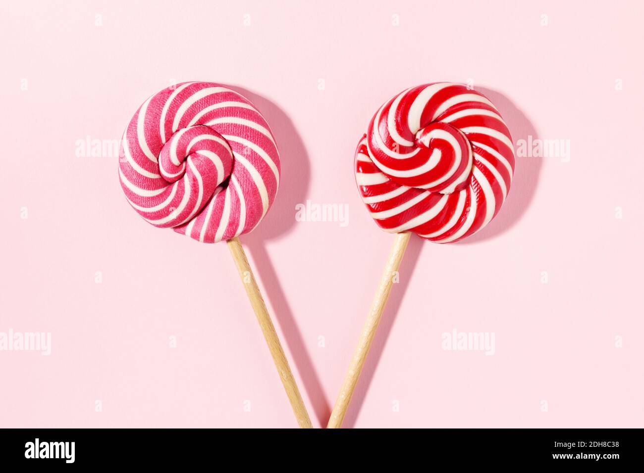 Due caramelle Lollipop con strisce a spirale rosse e bianche su sfondo  rosa. Concetto di compleanno. Piatto, minimo Foto stock - Alamy