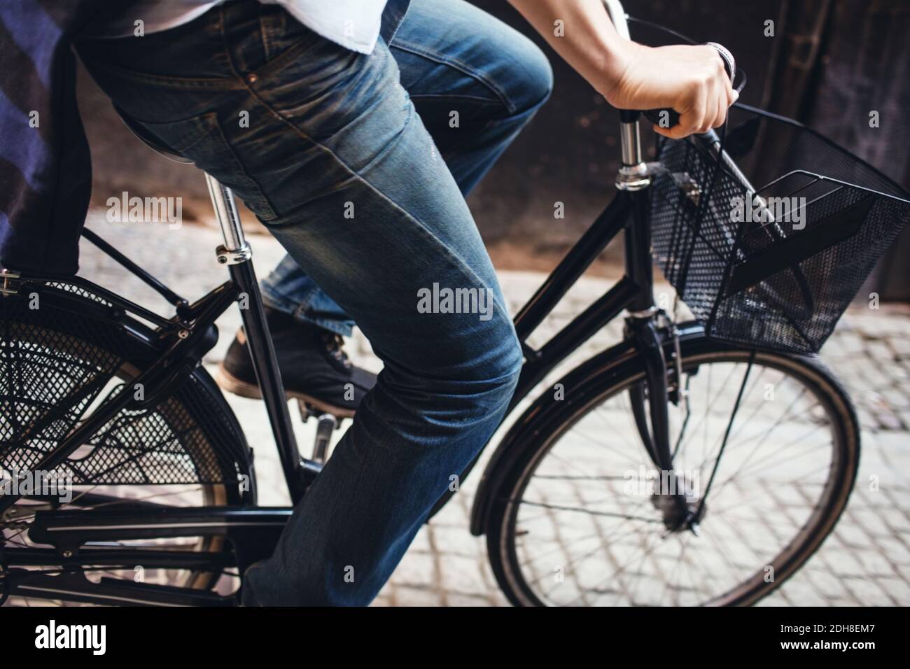 A metà strada di un uomo in bicicletta su strade acciottolate Foto Stock