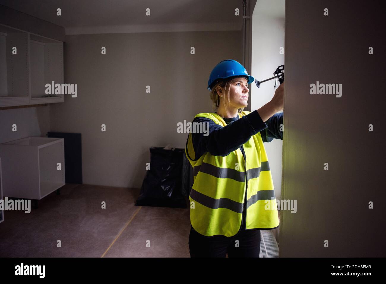 Operatrice manuale femminile che lavora con una finestra di vetro Foto Stock