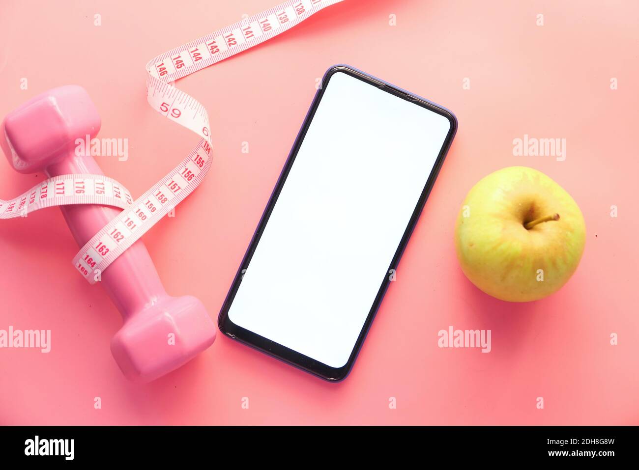 concetto di dieta sana con smartphone, mela e manubri su sfondo rosa Foto  stock - Alamy