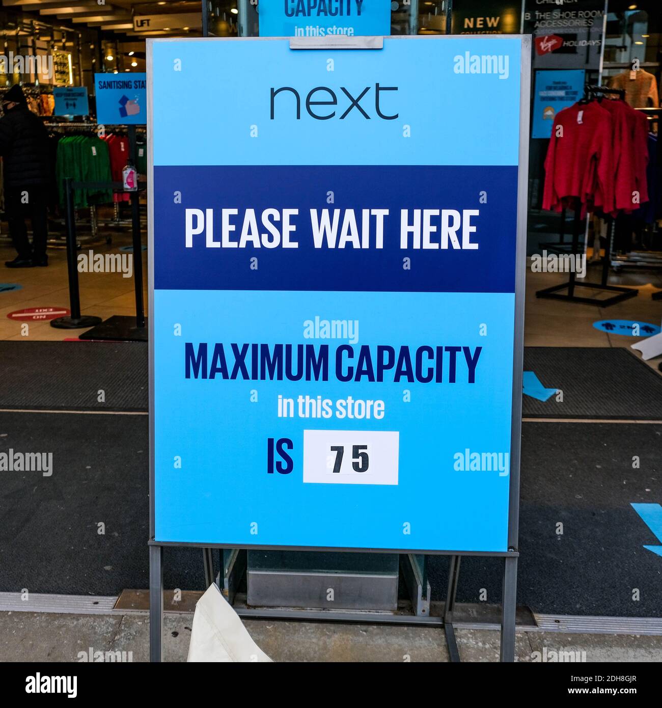Kingston London, dicembre 09 2020, cartello informativo che limita il numero di acquirenti autorizzati a entrare IN un negozio di vendita al dettaglio Next Fashion Foto Stock
