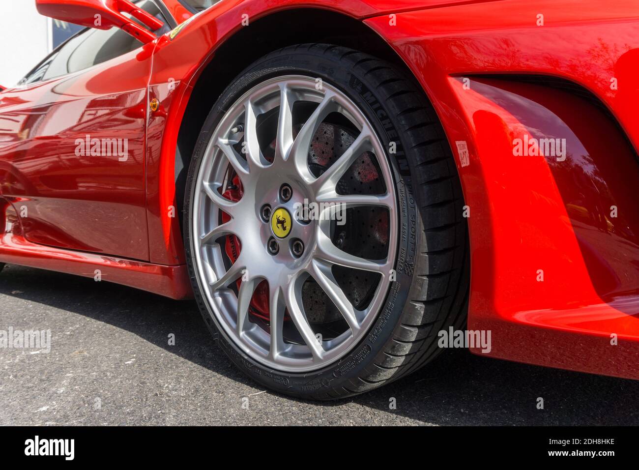 Primo piano del cerchio e dell'arco in lega argento Su una Ferrari rossa rosso corsa F430 sport coupé Foto Stock