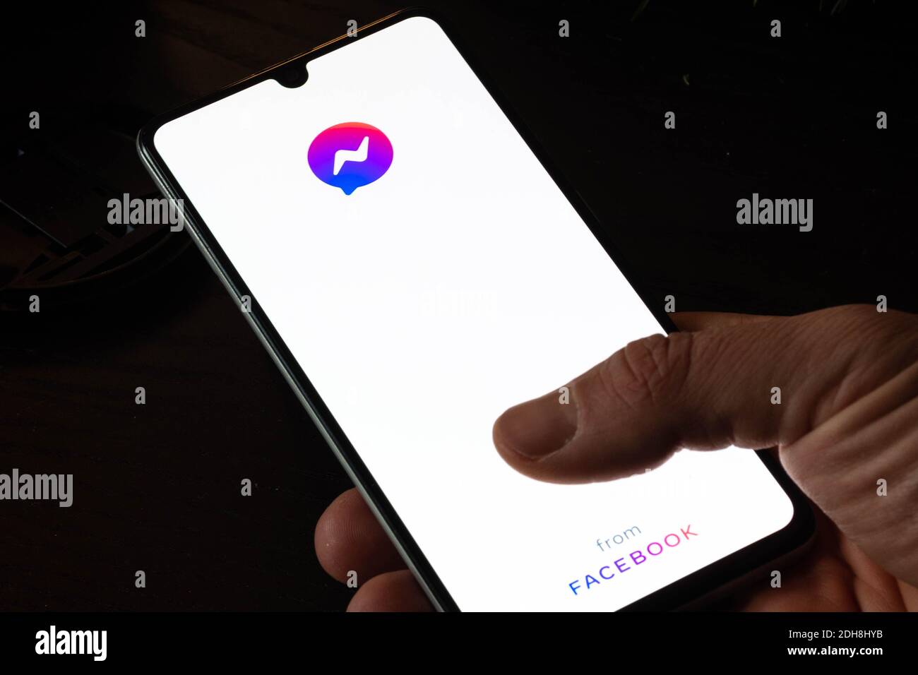 Icona Messenger sullo schermo del monitor con il dito dell'utente. App da Facebook. Messenger giù, si è bloccato, non funziona Foto Stock