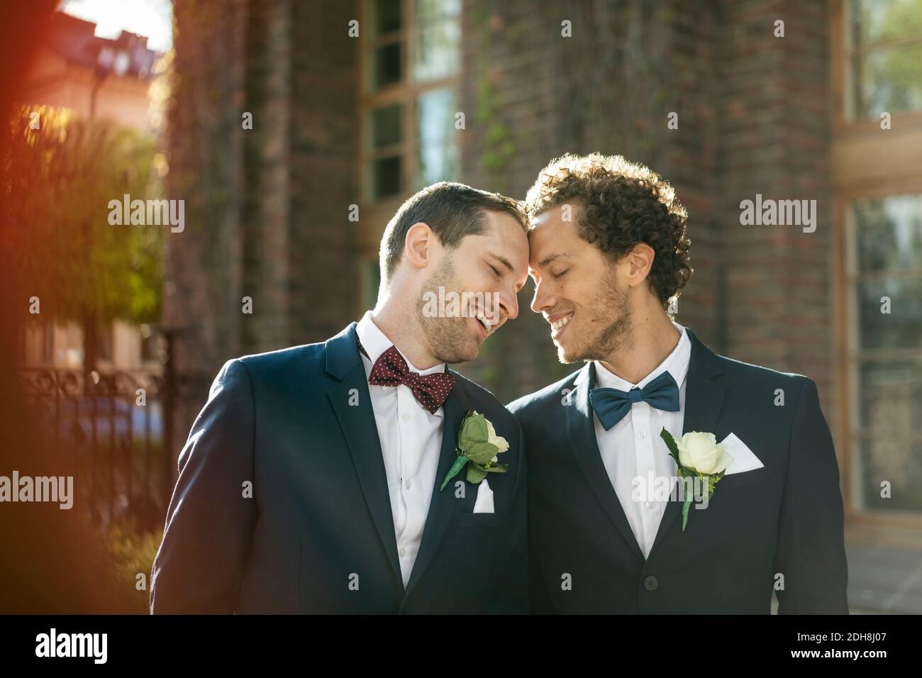 Felice coppia gay newlywed in piedi all'aperto Foto Stock
