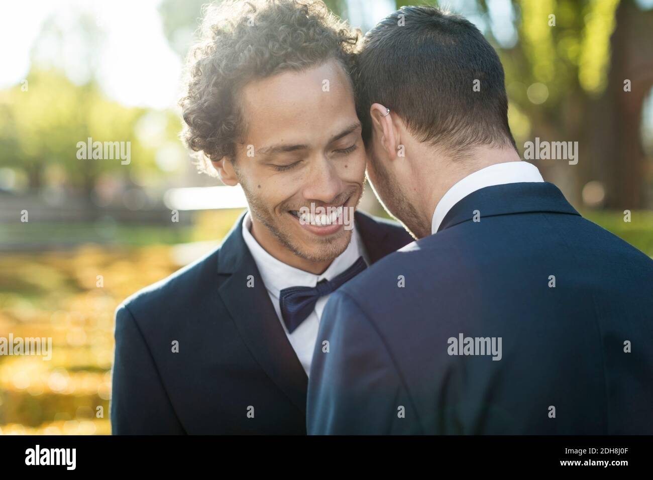 Coppia gay newlywed che abbraccia all'aperto Foto Stock
