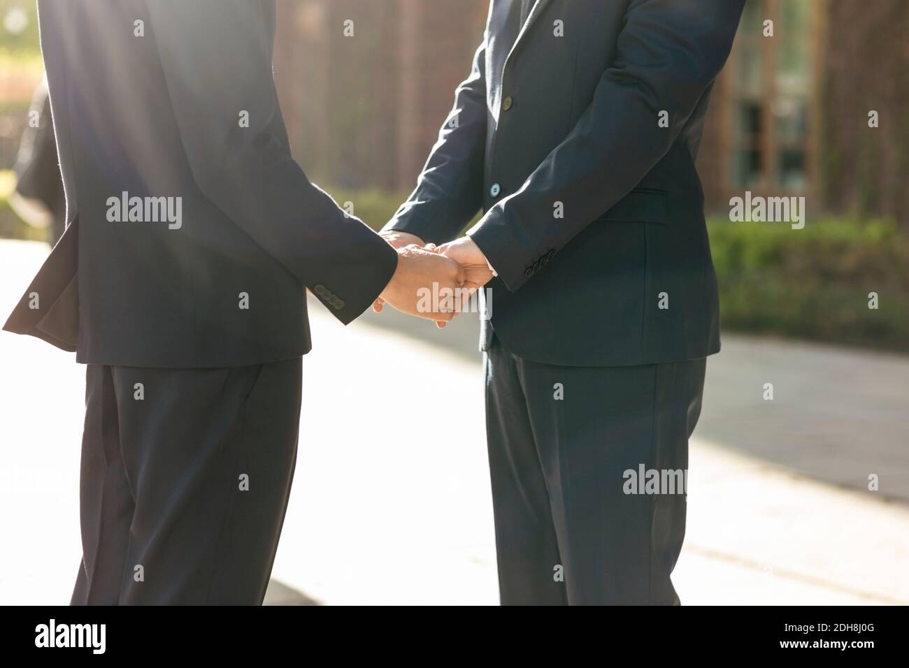 Sezione centrale della coppia gay newlywed che tiene le mani Foto Stock