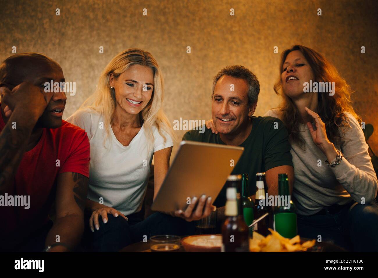 Donna sorridente che mostra il tablet digitale agli amici durante gli eventi sportivi Foto Stock