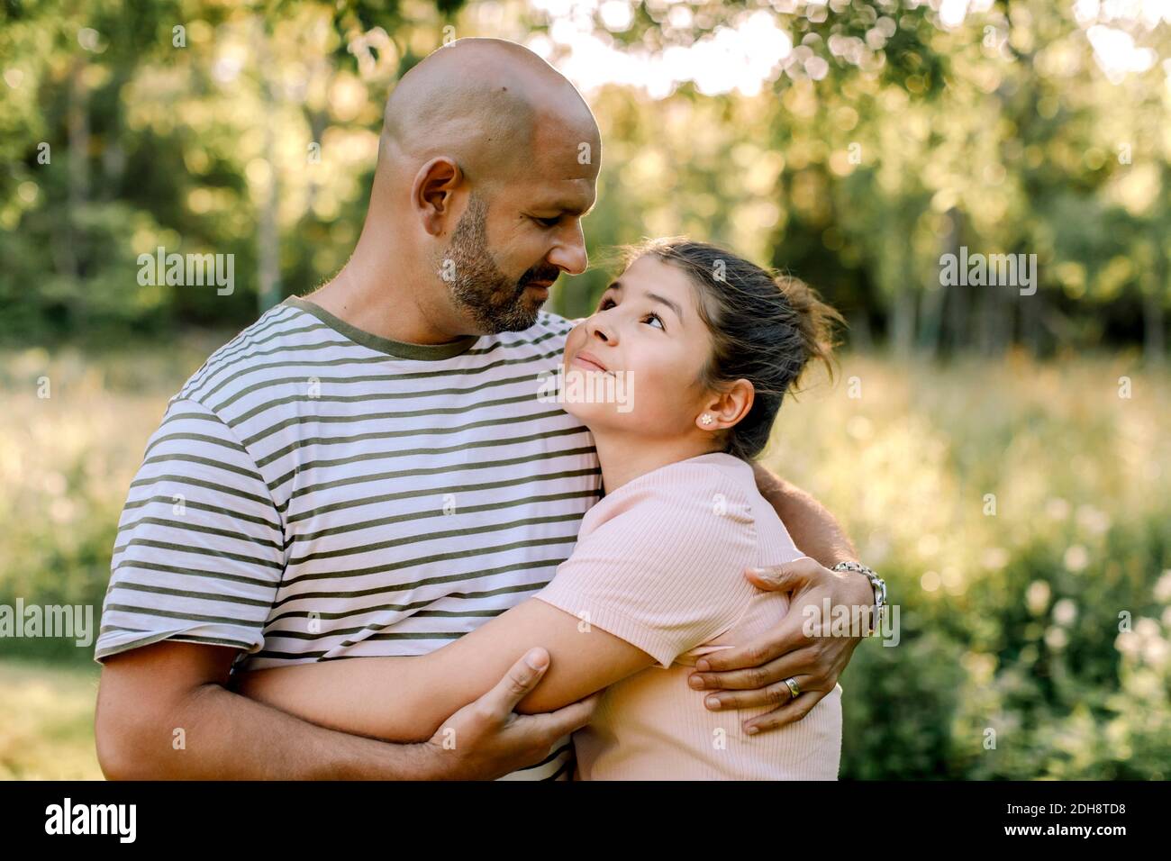 Padre abbracciando la figlia nel cortile Foto Stock