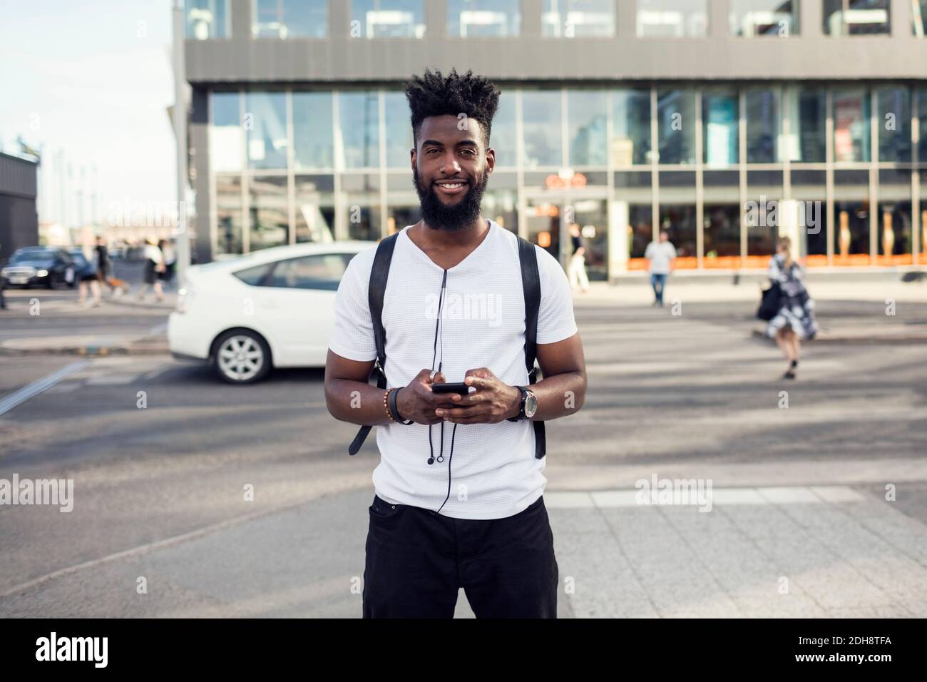 Ritratto di giovane uomo usando il telefono in città Foto Stock