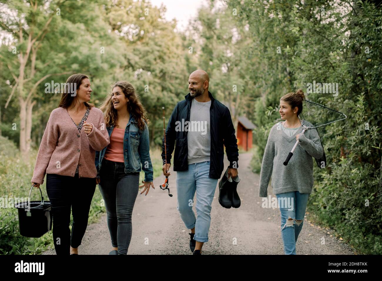 Figlie sorridenti con padre e madre sul sentiero durante le vacanze Foto Stock