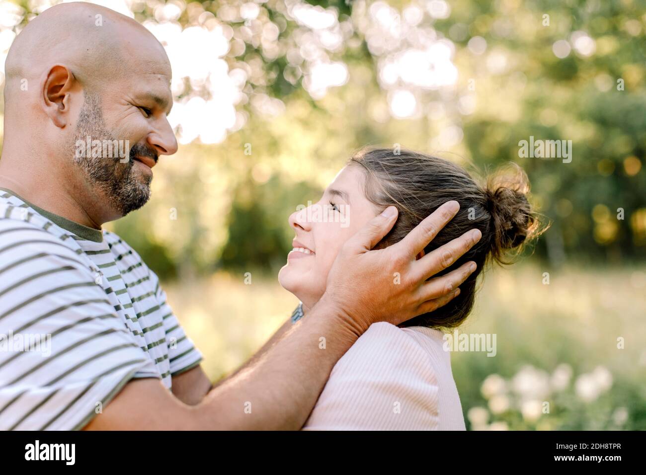 Padre e figlia si guardano l'un l'altro nel cortile Foto Stock