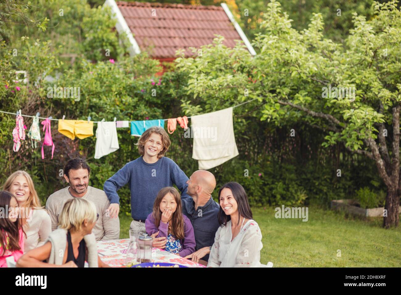 Famiglia e amici felici durante la festa in giardino nel cortile posteriore Foto Stock