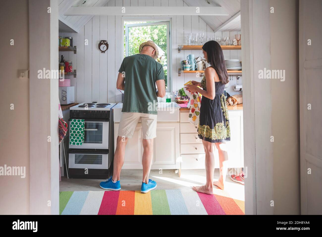 Coppia matura che lavora in cucina visto dalla porta di casa Foto Stock