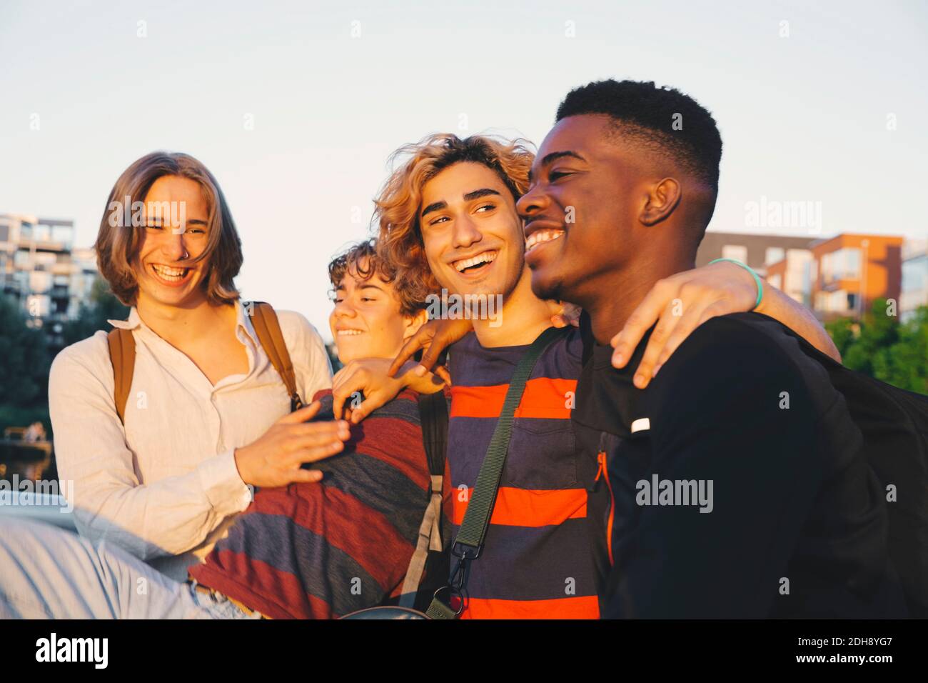 Sorridendo giovani e adolescenti amici maschi che si divertono insieme in città Foto Stock