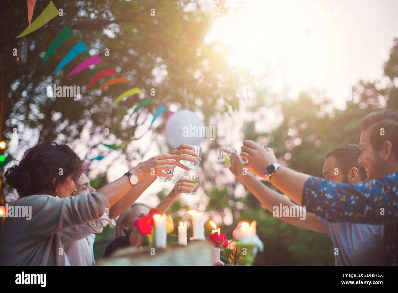 Amici multietnici che tostano bevande durante la festa in giardino Foto Stock