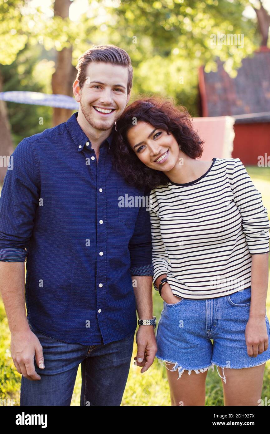 Ritratto di amici felici in piedi in cortile il giorno di sole Foto Stock