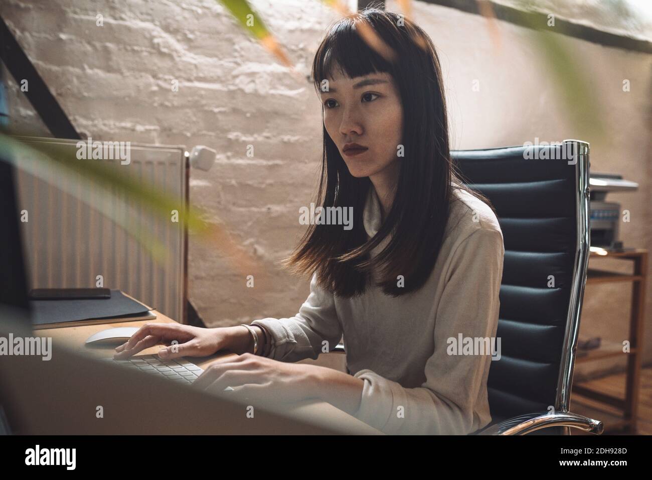 Donna d'affari che lavora sul computer sul posto di lavoro Foto Stock