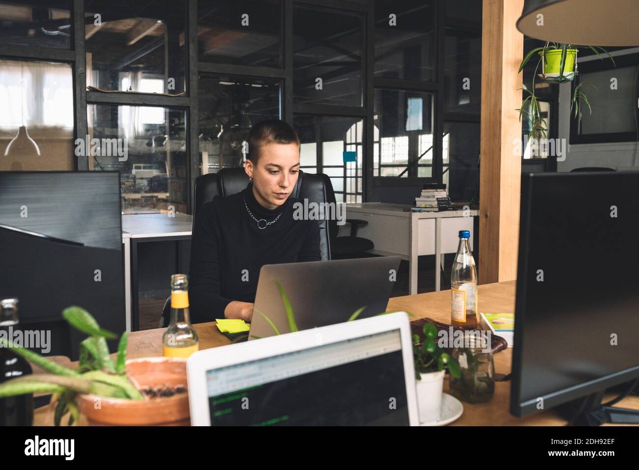 Donna d'affari che lavora su un computer portatile sul posto di lavoro Foto Stock