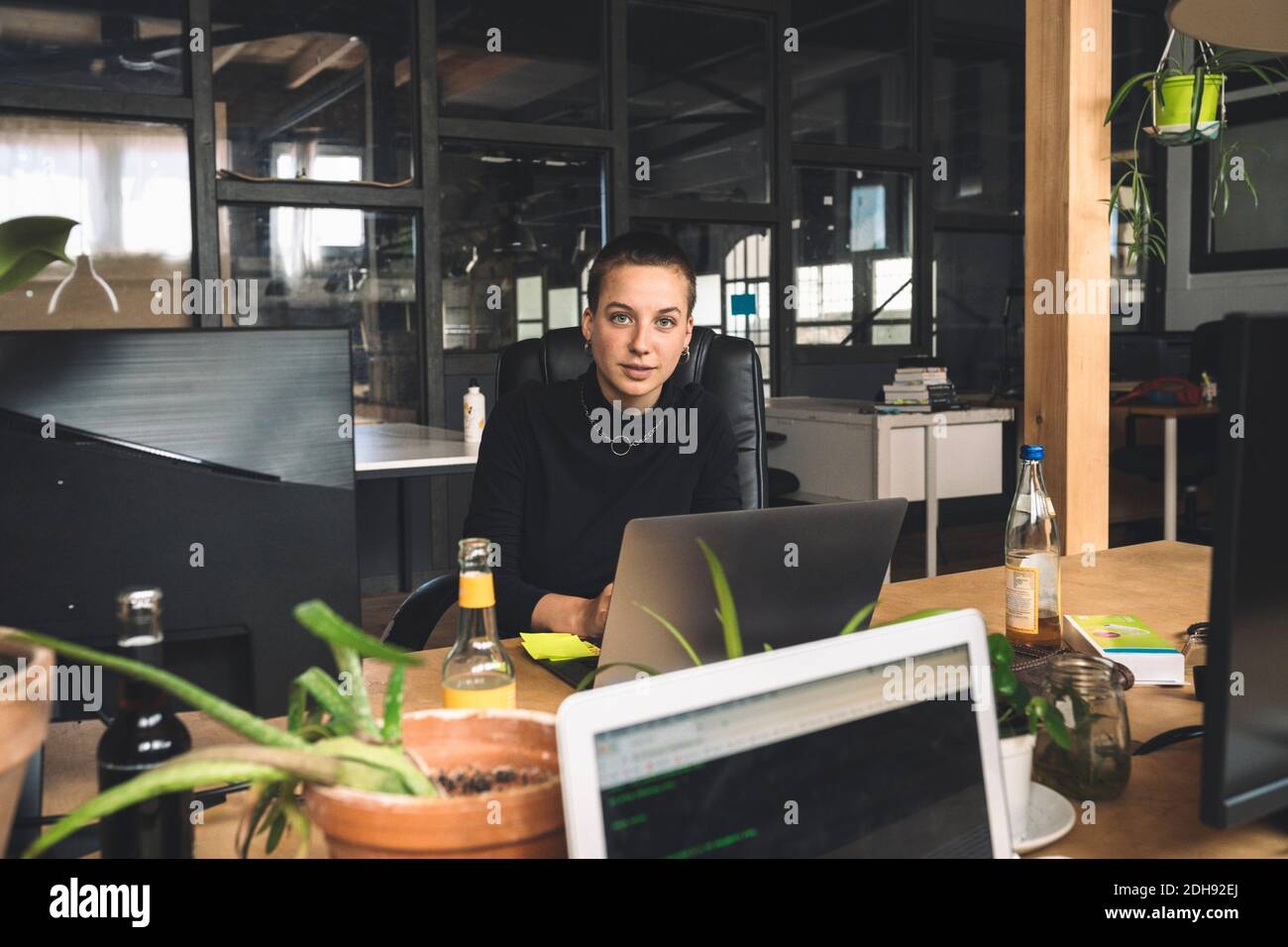 Ritratto di una donna d'affari che lavora su un computer portatile sul posto di lavoro Foto Stock