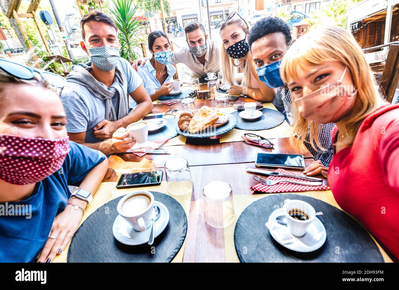 Amici che prendono selfie al caffè bar - persone che si divertono Insieme in caffetteria coperta da maschere facciali - nuovo normale concetto di stile di vita Foto Stock
