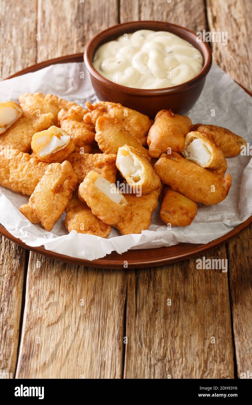 Kibbeling olandese, fritto profondo, pezzetti di pesce in pastella con salsa di remoulade, nel piatto sul tavolo. Verticale Foto Stock