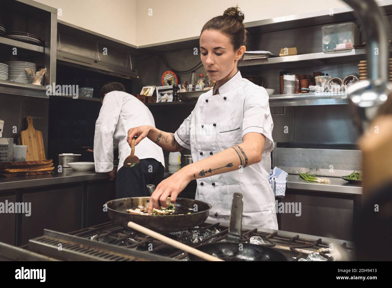 Chef femminile che prepara il cibo al ristorante Foto Stock