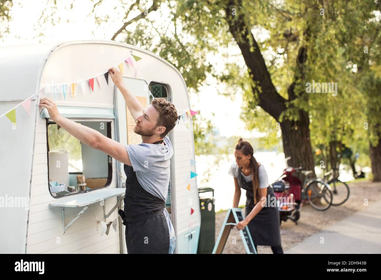 Proprietari che lavorano fuori camion di cibo sulla strada Foto Stock