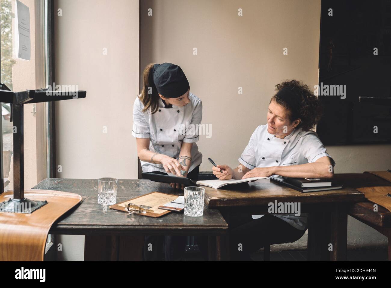 Le cuoco femminili discutono al tavolo nel ristorante Foto Stock