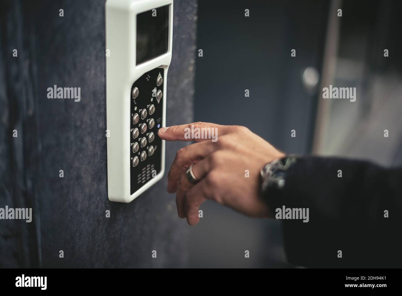 Immagine ritagliata della mano di un uomo d'affari che immette il codice chiave Foto Stock