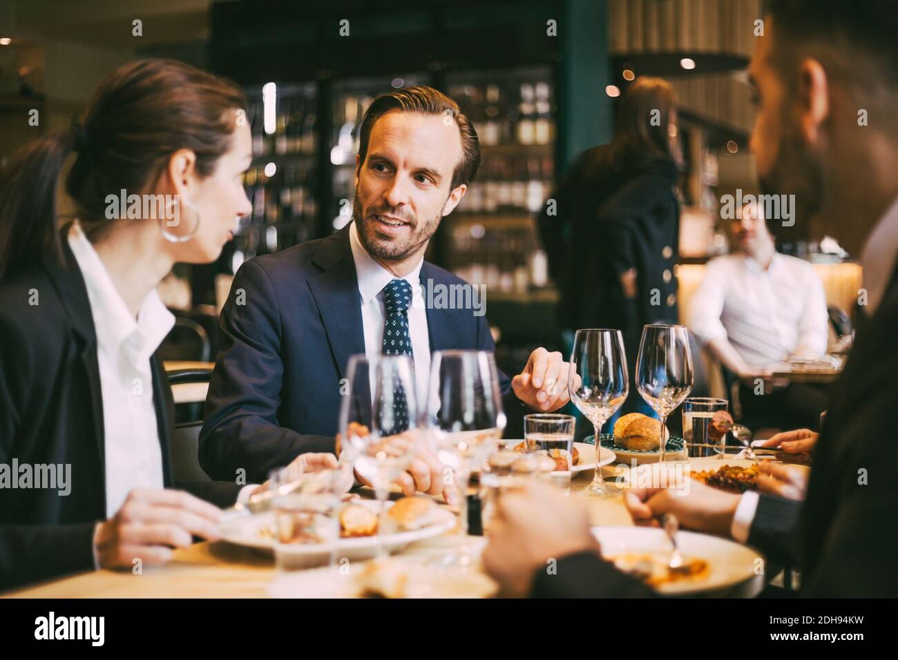 I colleghi di lavoro parlano mentre pranzano al ristorante Foto Stock