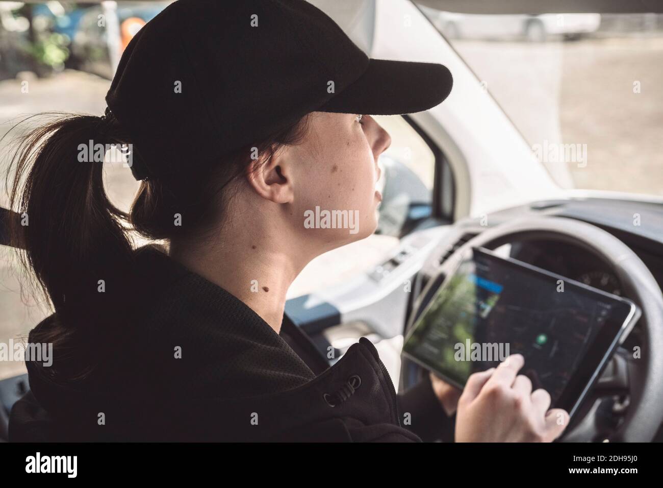 Vista laterale del conducente tramite tablet digitale per le indicazioni in carrello Foto Stock