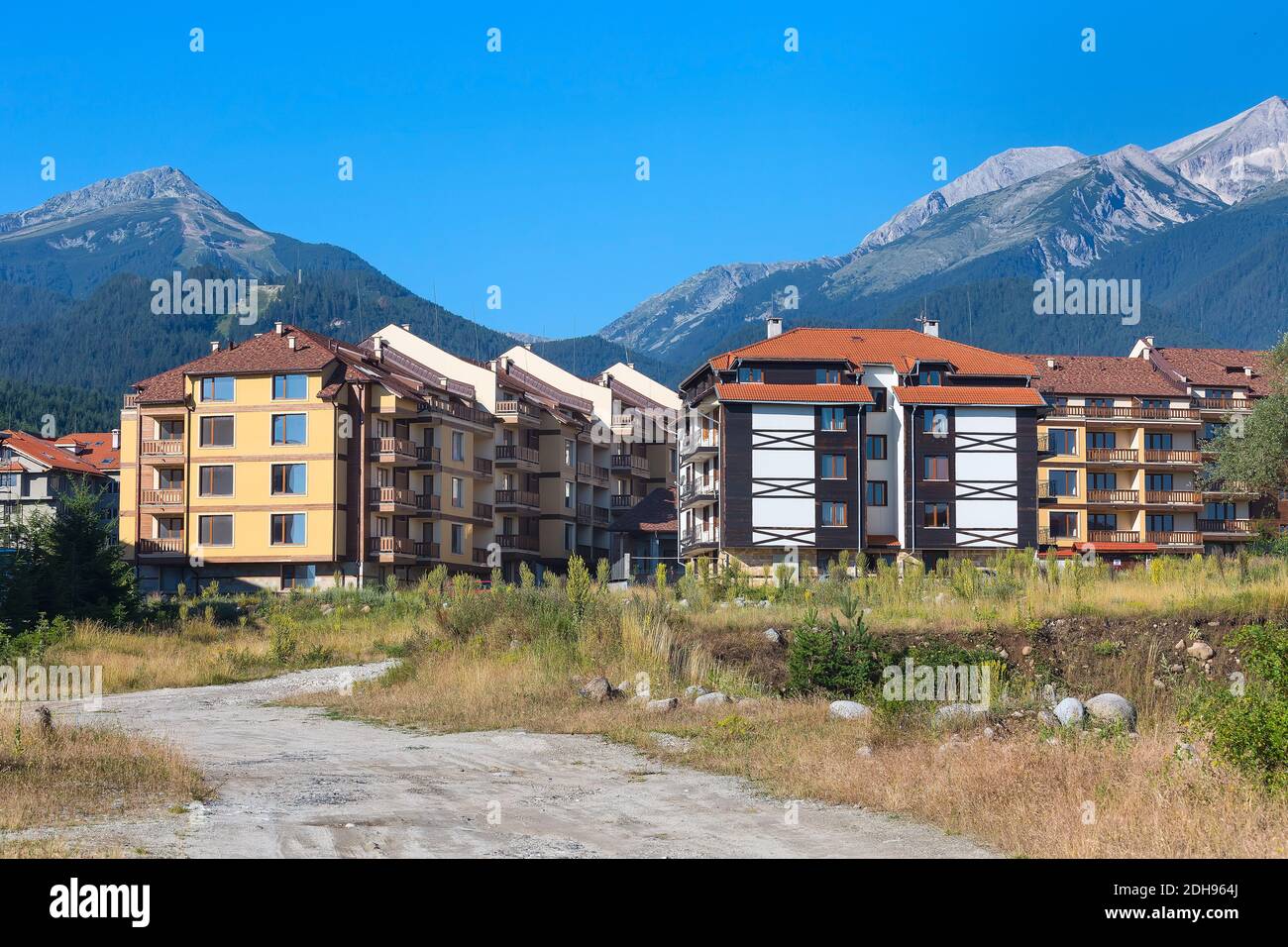 Case in legno chalet e panorama estivo montagne nella stazione sciistica bulgara Bansko, Bulgaria Foto Stock