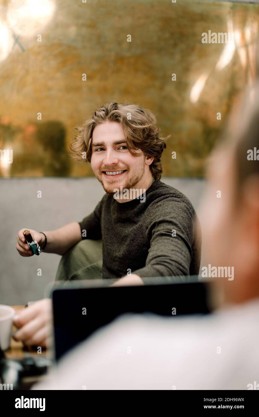 Ritratto di sorridente uomo d'affari seduto in ufficio Foto Stock