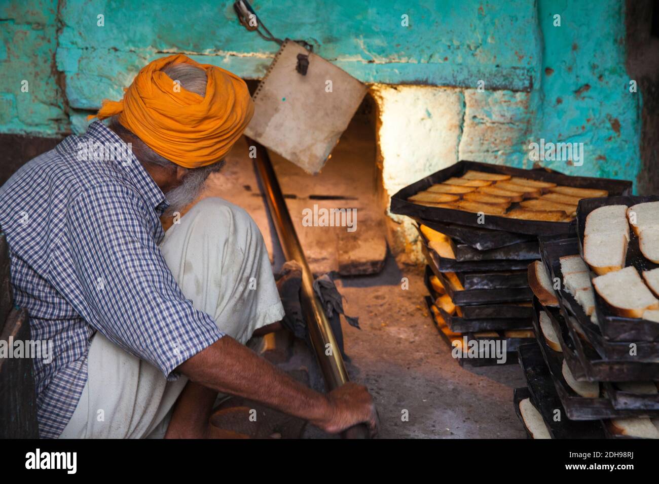 India, Punjab, Amritsar, uomo tostando il pane in forno a mattoni Foto Stock