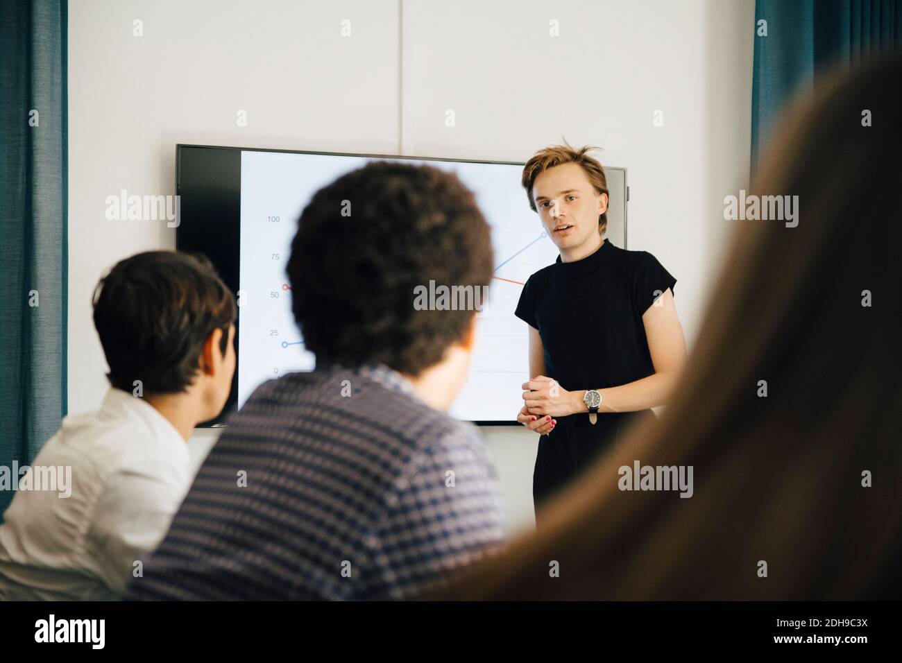 Uomo d'affari sicuro che spiega la strategia ai colleghi in sala durante riunione Foto Stock