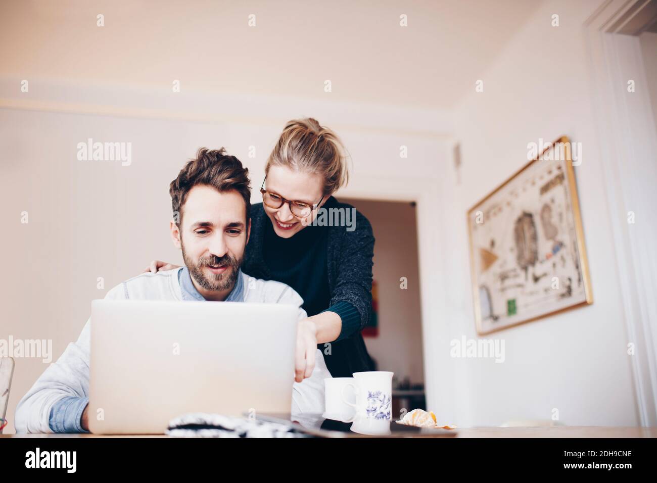 Vista ad angolo basso di una coppia felice che guarda il computer portatile camera domestica Foto Stock