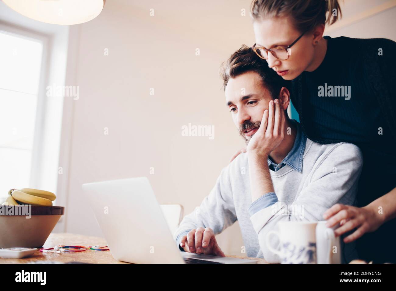 Vista ad angolo basso di una coppia che guarda il computer portatile in casa camera Foto Stock