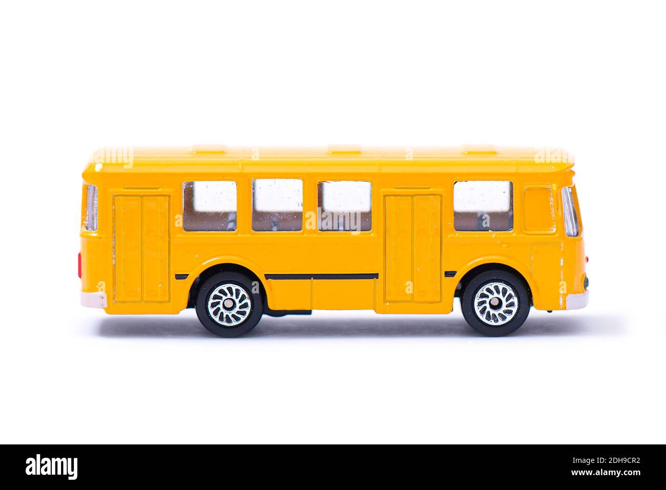 Modello in plastica di un vecchio autobus giallo, giocattolo, in miniatura isolato su bianco Foto Stock