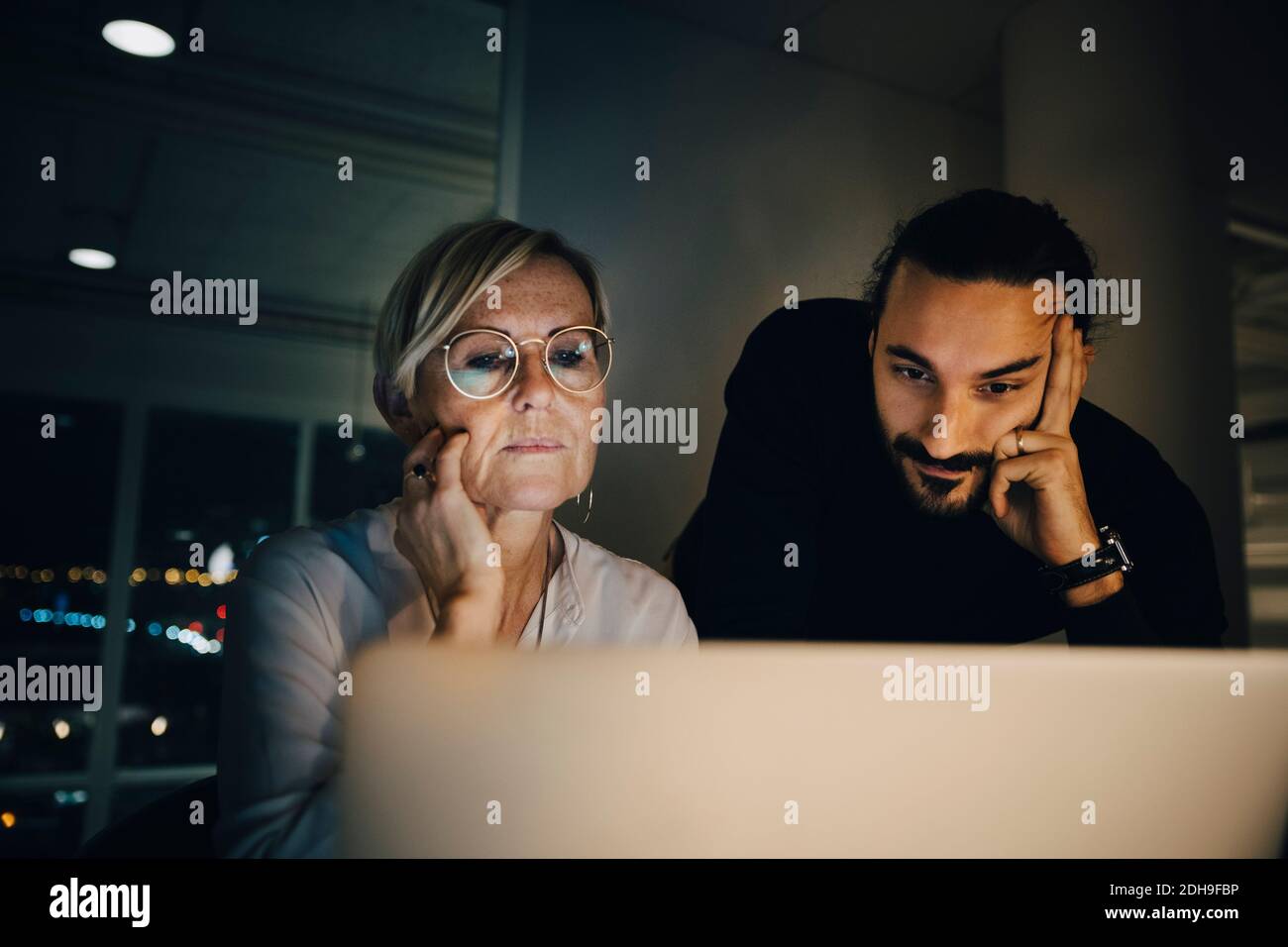 Colleghi multietnici che staranno al computer portatile durante la riunione in ufficio Foto Stock