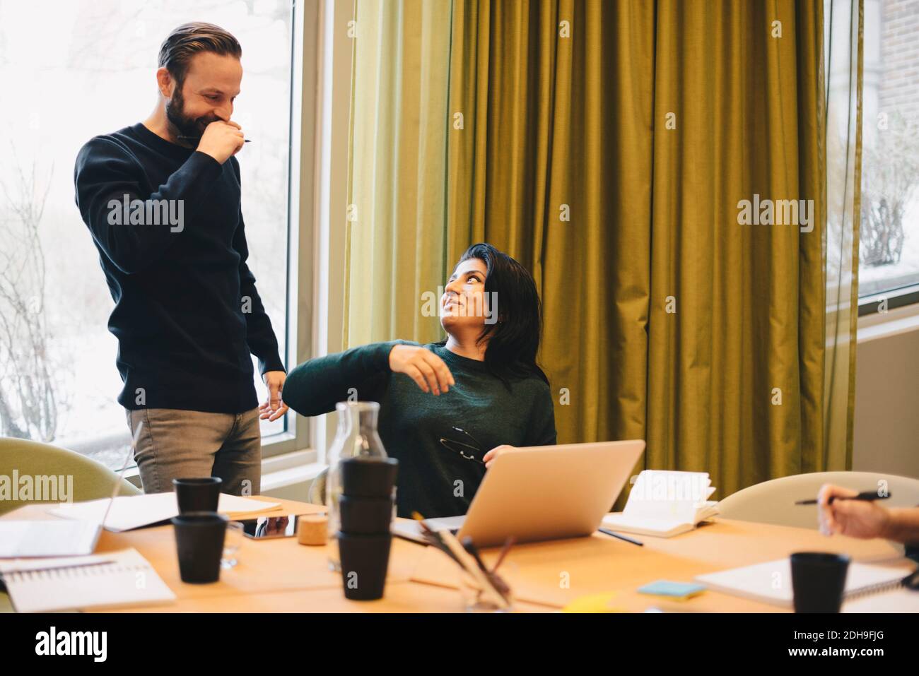 Un collega di lavoro felice che si guarda l'un l'altro durante la riunione sala riunioni Foto Stock