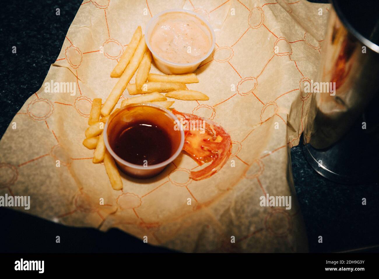 Vista ad alto angolo delle patatine fritte con salsa al tavolo in caffetteria Foto Stock