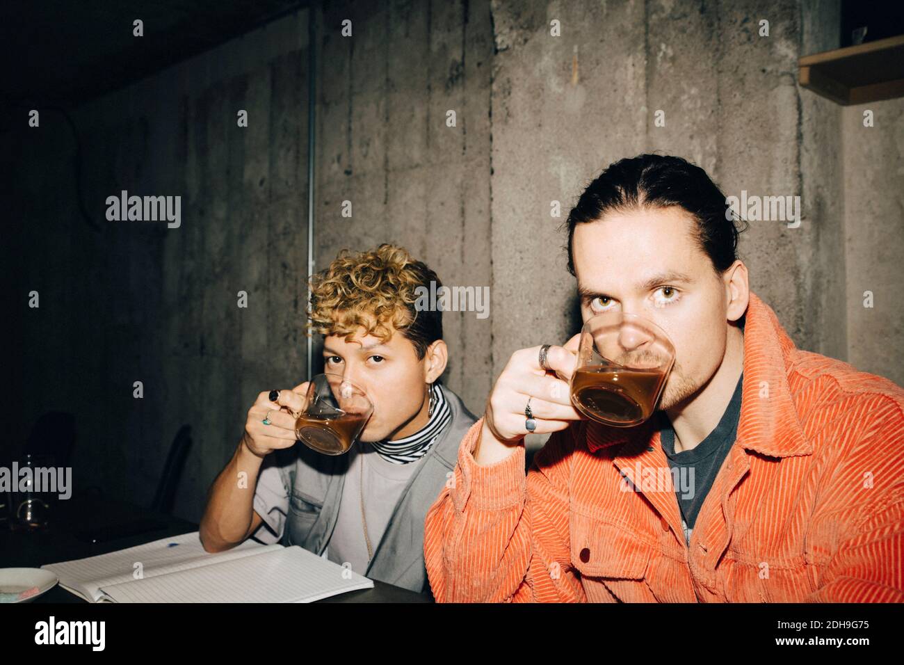 Ritratto di imprenditori sorridenti che bevono caffè mentre si siedono in creativo ufficio Foto Stock