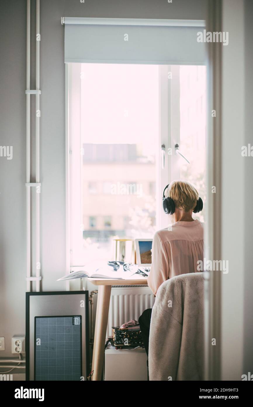 Donna in ufficio a casa che lavora con un computer portatile Foto Stock